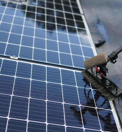 Close-up of solar panel cleaning using a brush tool in Tampa, Florida.